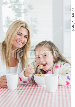 Little girl eating cereal at breakfast with her mother Little girl eating cereal at breakfast with her mother 6834160