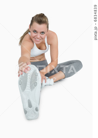 Smiling woman stretching her leg 6834839