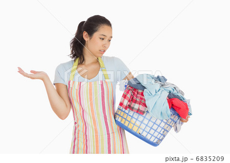 Quizzical looking young woman looking at basket Quizzical looking young woman looking at basket 6835209