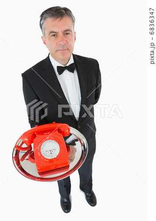 Waiter holding a red dial phone 6836347