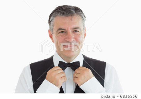 Waiter adjusting his own bow tie Waiter adjusting his own bow tie 6836556