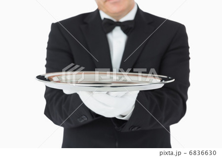 Man holding a silver tray with both hands 6836630