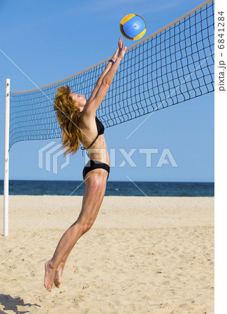 Attractive woman plays in beach volleyball 6841284