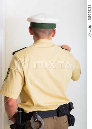 Police officer knocking on front door of home 6846351