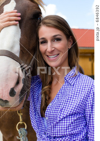 Young woman in the stable with horse in sunshine Young woman in the stable with horse in sunshine 6846392