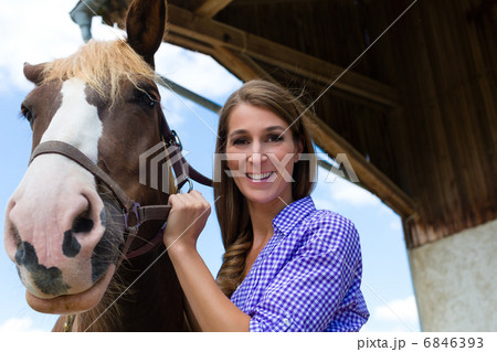 Young woman in the stable with horse at sunshine Young woman in the stable with horse at sunshine 6846393