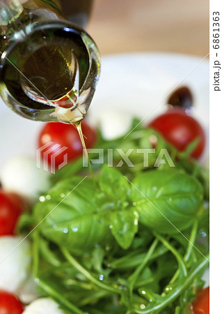 Olive Oil Dressing Pouring Onto Fresh Salad 6861363