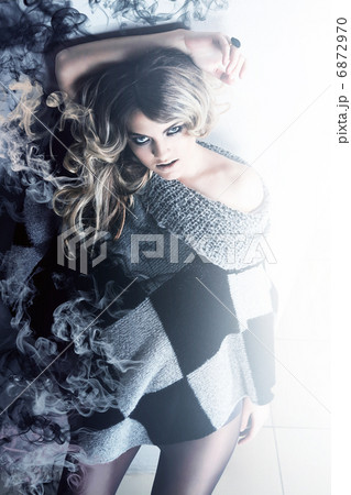 blonde woman in sweater with smoke 6872970