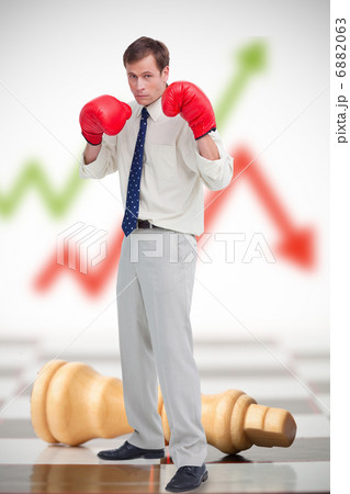 Businessman in boxing gloves on chessboard Businessman in boxing gloves on chessboard 6882063