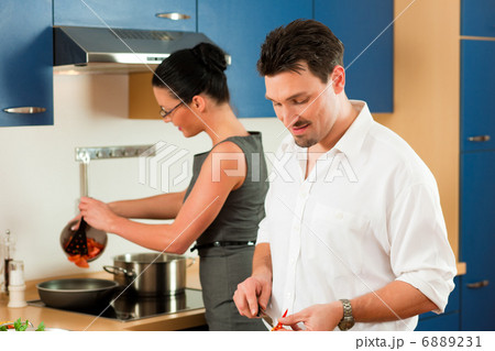 Couple cooking together in kitchen Couple cooking together in kitchen 6889231