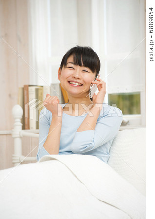 ベッドでスマートフォンを楽しむ女性 ベッドでスマートフォンを楽しむ女性 6889854