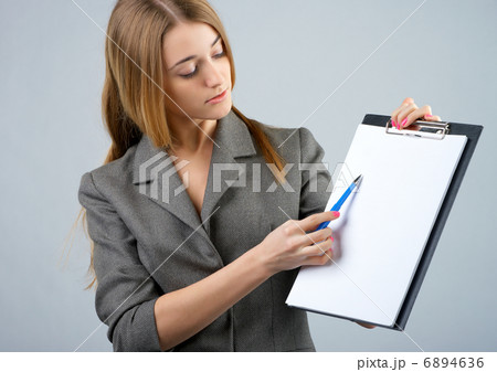 Businesswoman holding a clipboard and showing something Businesswoman holding a clipboard and showing something 6894636