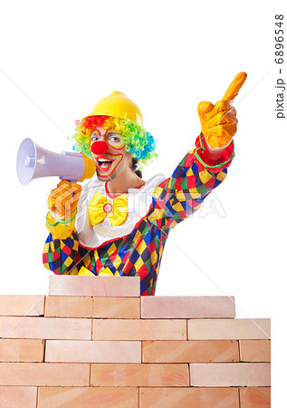Bad construction concept with clown laying bricks Bad construction concept with clown laying bricks 6896548