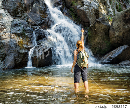 Female hiker looking at waterfall 6898357