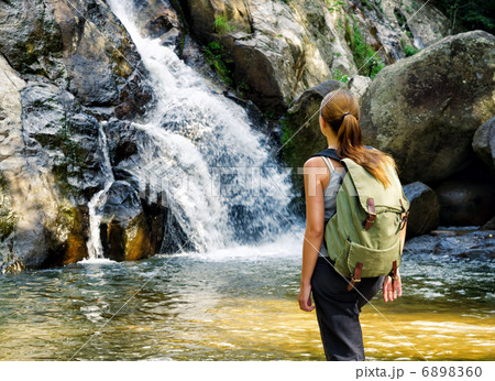 Female hiker looking at waterfall Female hiker looking at waterfall 6898360