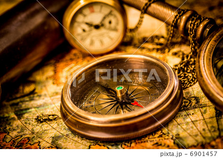 Vintage compass lies on an ancient world map. 6901457