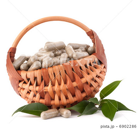 Herbal drug capsules in wicker basket. Alternative medicine conc Herbal drug capsules in wicker basket. Alternative medicine conc 6902286