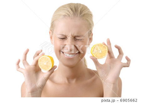 Beautiful young girl holding a sour lemon isolated 6905662