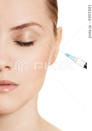 Beautiful woman gets an injection in her face isolated on white 6905981