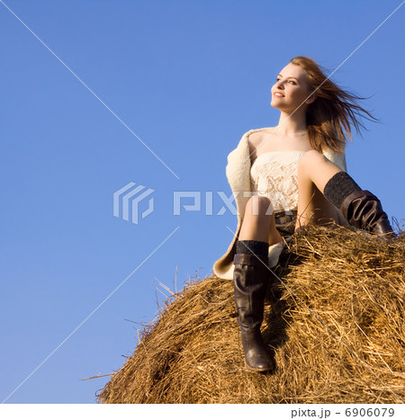 beautiful woman siting on haystack under blue heaven 6906079