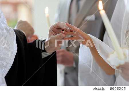 Priest putting the ring on brides finger Priest putting the ring on brides finger 6906296