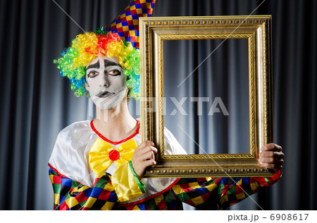 Clown with picture frames in studio Clown with picture frames in studio 6908617