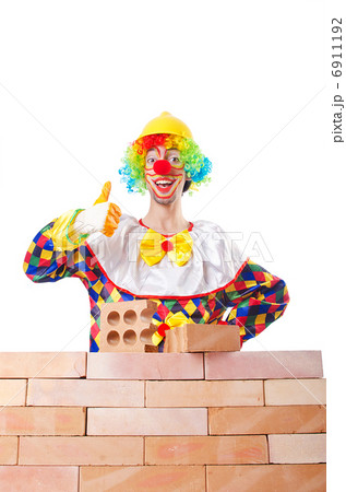 Bad construction concept with clown laying bricks 6911192
