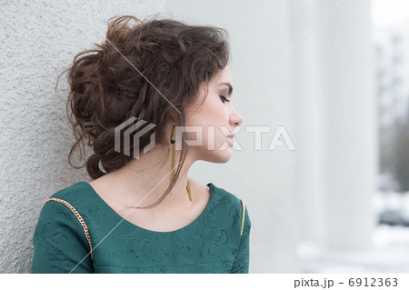 Romantic Caucasian Woman in Green Dress over White Wall outside. Solitude Romantic Caucasian Woman in Green Dress over White Wall outside. Solitude 6912363