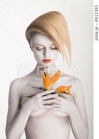 Bodypainting. Enigmatic Gorgeous Woman with Strelitzia flower in hands. Painted Skin 6912365