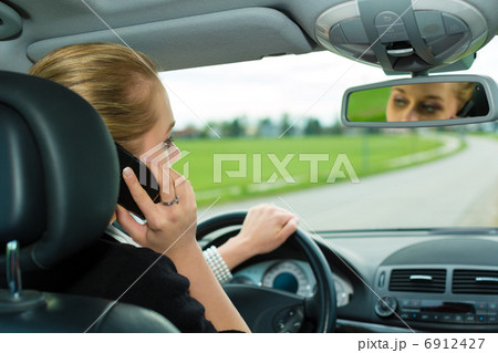 Young woman with telephone in car Young woman with telephone in car 6912427