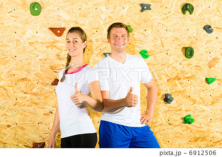 Woman and man standing at climbing wall 6912506