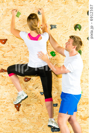 Woman and man climbing at climbing wall 6912507