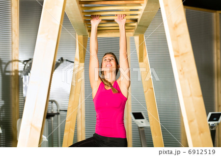 Woman hanging at high or horizontal bar Woman hanging at high or horizontal bar 6912519