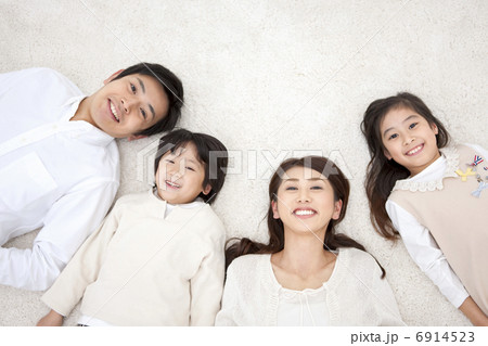 仰向けに寝転んでいる家族4人 6914523