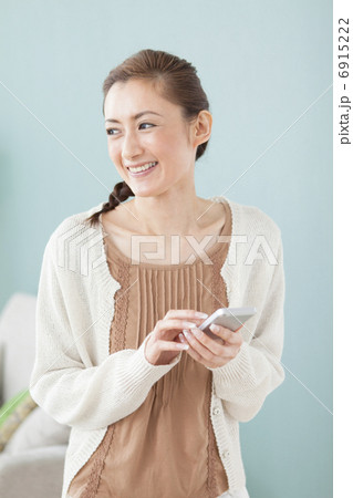 スマートフォンを持っている笑顔の女性 6915222