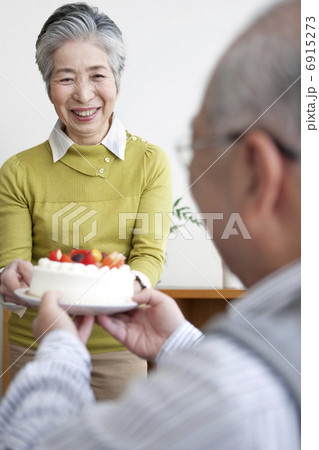 ケーキを持つ中高年夫婦 6915273