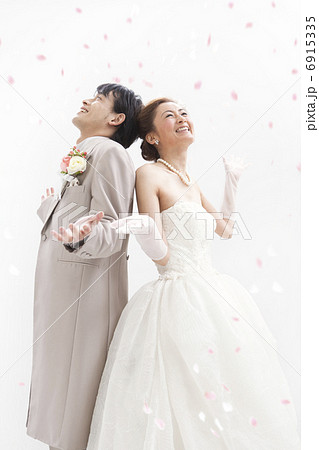 フラワーシャワーを浴びる新郎新婦 6915335