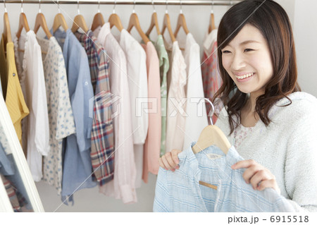 鏡の前で洋服を選ぶ女性 6915518