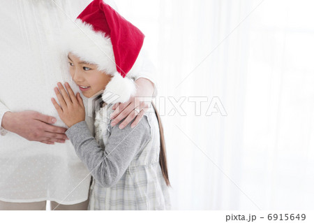 妊婦のお腹に触れる女の子 6915649