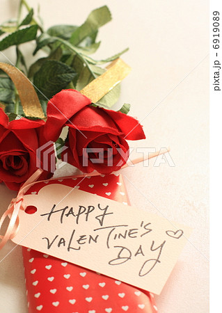 造花の赤いバラと手書きメッセージカードの写真素材