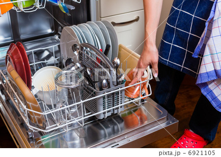 Housewife is doing the dishes with dishwasher 6921105