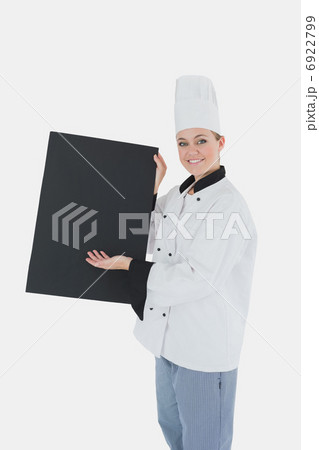 Female chef in uniform displaying black billboard 6922799