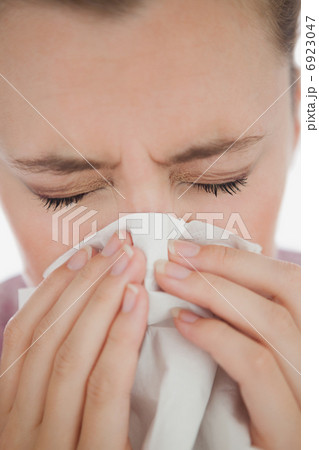 Woman blowing her nose 6923047