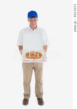 Mature delivery man looking at fresh pizza Mature delivery man looking at fresh pizza 6923051
