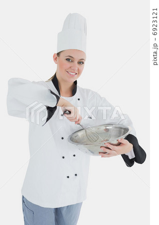 Happy female chef holding wire whisk and mixing bowl 6923121