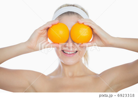 Happy woman holding oranges in front of eyes Happy woman holding oranges in front of eyes 6923318