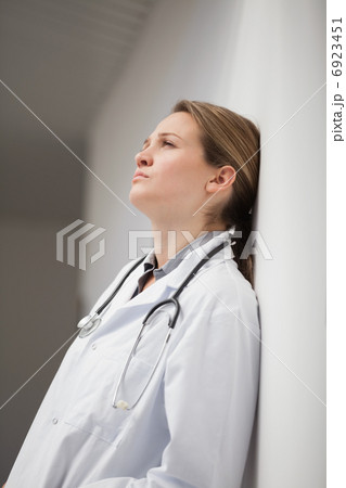 Thinking doctor sitting on a hallway 6923451