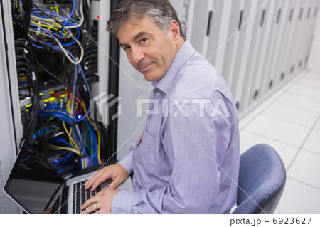 Man doing server maintenance with notebook Man doing server maintenance with notebook 6923627
