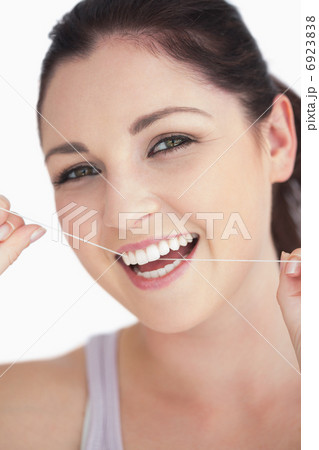 Smiling woman using dental floss 6923838