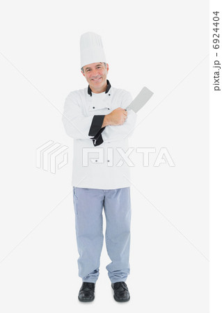 Man in chef uniform holding meat cleaver Man in chef uniform holding meat cleaver 6924404